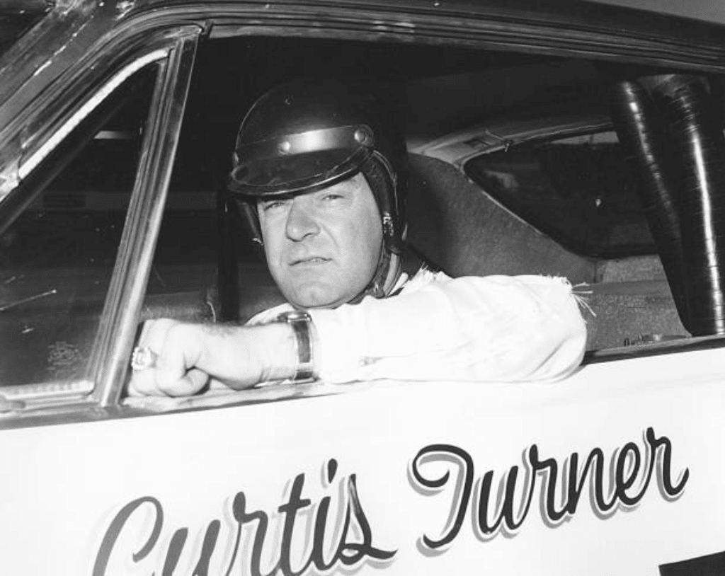 Curtis Turner looks on.